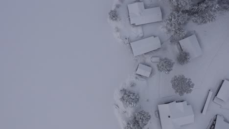 Bird's-Eye-View-Over-Cabins-Covered-In-Snow-During-Winter-In-Indre-Fosen,-Norway---drone-shot