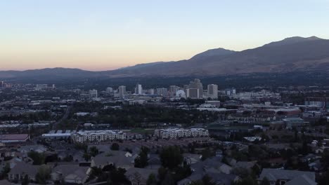 Aerial-shot-of-the-skyline-and-the-mountains-in-Reno,-Nevada-at-sunset