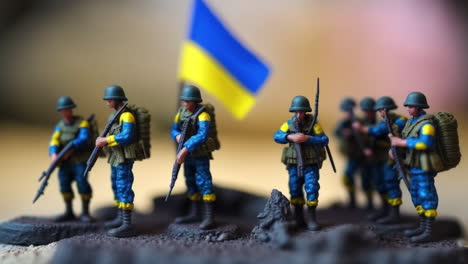 Ukrainische-Miniatur-Spielzeugsoldatenarmee-Und-Ukrainische-Flagge-In-Kriegsszenenillustration,-Makro-Tilt-Shift-Konzept-Des-Kampfes