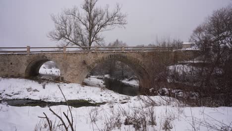 Stone-bridge-with-trees-in-the-background-on-a-winter-snowy-day,-medieval-architecture-in-Albania