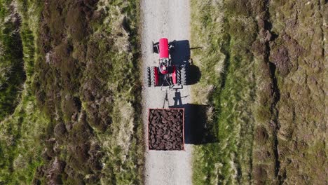 Birds-eye-view-drone-shot-of-a-tractor-full-of-peat