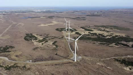 Drone-shot-of-a-wind-farm-with-spinning-wind-turbines-generating-green,-sustainable-energy