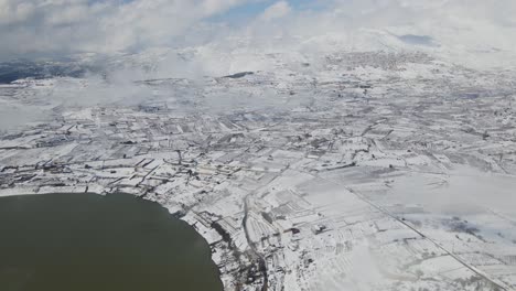 Vista-Aérea-De-Drones-Del-área-Del-Lago-Ram-Y-El-Monte-Hermón-Cubierto-De-Nieve,-Israel