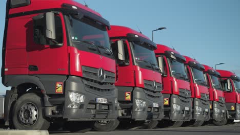 A-row-of-red-heavy-duty-trucks-in-a-dealership-parking-lot
