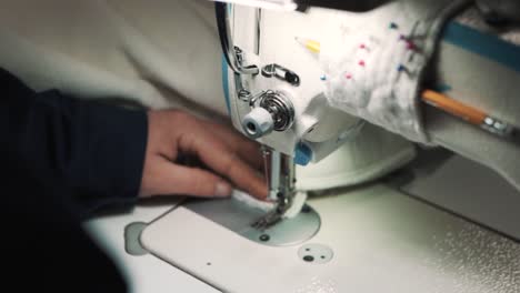 Close-up-of-a-woman's-hands-sewing-fabric-on-a-factory-sewing-machine-to-make-a-cover-for-a-mattress