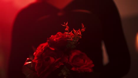 Zeitlupenaufnahme-Einer-Frau,-Die-Unter-Rotem-Licht-Einen-Blumenstrauß-Hält