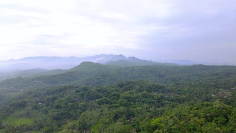 Aerial-view-of-green-rain-forest-and-hill-with-cloudy-sky---Tropical-Country