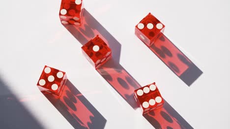 Red-gambling-craps-casino-dice-in-bright-sunshine-with-moving-shadow