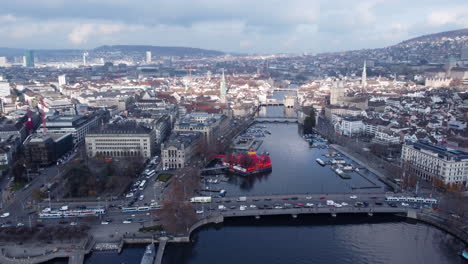 Aerial-flying-over-Zurich-on-cloudy-sunny-day,-traffic-on-bridge