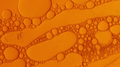 Abstrakte-Öltropfen-Hintergrund-In-Orangefarbener-Flüssigkeit-Für-Kosmetische-Behandlungen-Hydroge