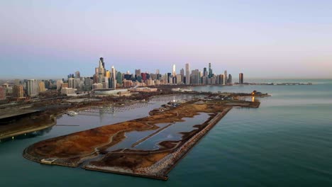 Aerial-tracking-view-of-the-Northerly-Island-and-the-Chicago-skyline,-during-sunrise