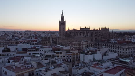 Luftwagen-In-Richtung-Der-Großen-Gotischen-Kathedrale-Von-Sevilla-Nach-Sonnenuntergang,-Umgeben-Von-Häusern