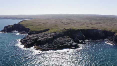 Dynamic-drone-shot-of-a-lighthouse-surrounded-by-cliffs-and-nesting-sea-birds