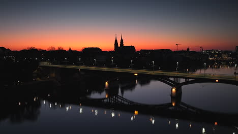 Drone-dolley-shot-of-the-Wettstein-bridge-with-the-silhouettes-of-the-Munster-Cathedral-in-the-skyline-of-the-city-Basel-during-after-sunset
