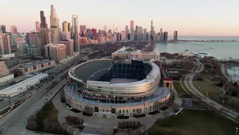 Aerial-view-orbiting-around-the-Solider-field-Stadium,-sunrise-in-Chicago,-USA