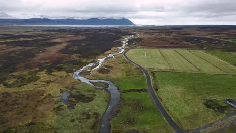 Fluss-Durch-Landwirtschaftliches-Ackerland-In-Der-Isländischen-Landschaft-Im-Sommer,-Luftaufnahme
