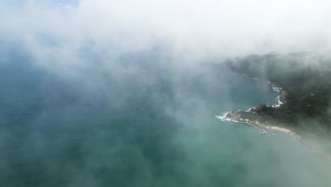 Reveal-of-Hainan-Island-Coastline,-South-China-Sea,-Dramatic-Aerial-Flight-in-Clouds