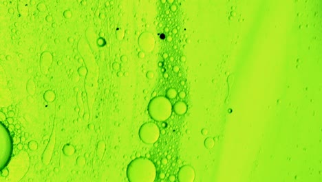 Grünes-öliges-Gel,-Das-Mit-Ölblasen-über-Eine-Fleckenartige-Oberfläche-Fließt