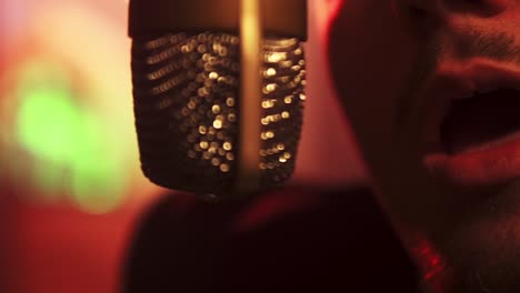slowmotion-bokeh-shot-of-a-man-singing-into-a-hanging-microphone-in-the-studio