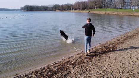 Guy-and-his-pet-dog-playing-fetch-in-the-water