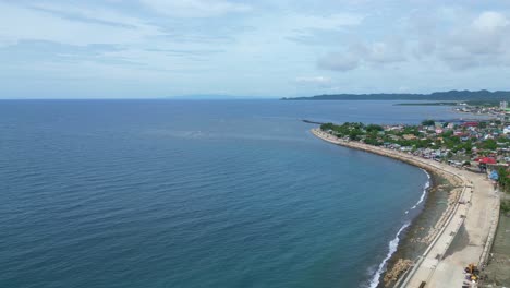 Aerial,-Rising-View-of-Wide-Bay-and-Seawall-beside-the-Coastal-Town-of-Virac,-Catanduanes,-Philippines,-Asia