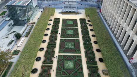 Garden-with-square-shaped-bushes-next-to-a-statue-In-Brussels-aerial-drone-shot