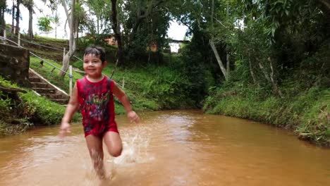 Child-Running-Towards-Camera-In-Slow-Motion-In-Unpolluted-Water-Stream