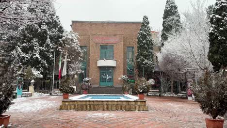 Brick-mud-clay-tile-floor-white-heavy-snow-fall-in-desert-city-of-Tehran-Iran-and-happy-cheerful-people-who-play-hit-fight-with-snowball-and-walking-Persian-Garden-in-city-center-ancient-architecture