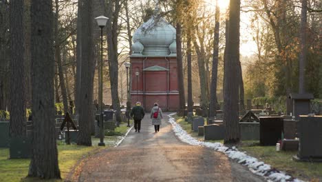 Elderly-couple-walking-in-a-graveyard-during-the-sunset