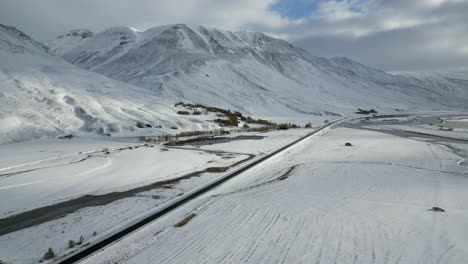 Wunderschönes-Gebirgstal-Mit-Straße-Im-Verschneiten-Isländischen-Winter,-Luftlandschaft