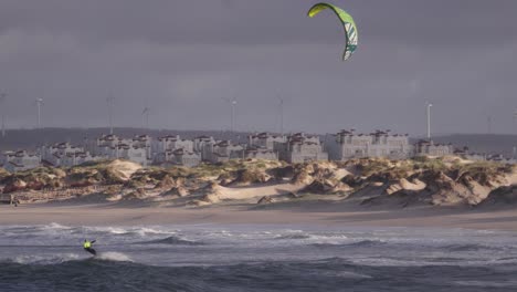 Kiteboarding-on-waves-of-Atlantic-ocean-in-slow-motion,-stable-copyspace-cinematic-view