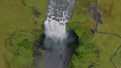 Aerial:-Top-down-and-backwards-reveal-of-Skogafoss-waterfall-in-Iceland