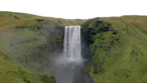 Aerial:-Flying-towards-the-Skogafoss-waterfall-in-Iceland-on-a-cloudy-day