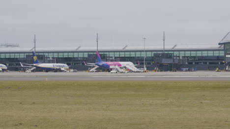 Planes-of-low-cost-airlines-Wizzair-and-Ryanair-stand-in-front-of-the-departure-terminal-at-Gdansk-airport-waiting-for-passengers
