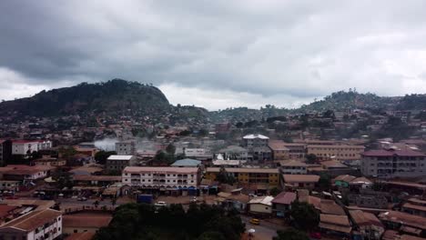 Aerial-view-of-the-cityscape-of-Yaounde-with-a-smoking-house,-in-cloudy-Cameroon,-Africa