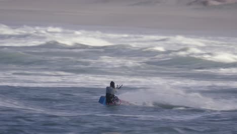Fast-kiteboarder-jumping-on-big-ocean-waves,-adrenaline-water-sport