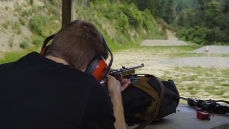 Man-Firing-Shotgun-At-An-Outdoor-Firing-Range