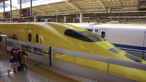 Arzt-Gelb,-Spezieller-Diagnose-Shinkansen-An-Bahnhöfen,-Während-Menschen-Fotos-Machen