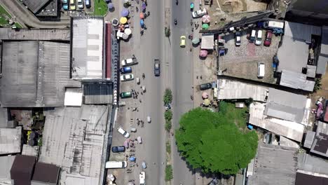 Aerial-view-over-streets-and-a-traffic-circle-in-sunny-Douala-city,-Cameroon,-Africa---top-down,-drone-shot