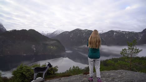 Female-photographer-facing-away-photographs-Veafjorden-Fjord,-Norway