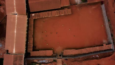 Birds-eye-drone-shot-above-an-urban-street-soccer-game-in-the-suburbs-of-Yaounde,-Cameroon