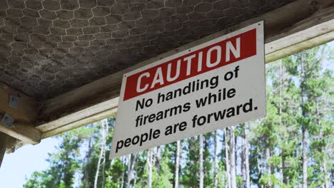 Caution,-No-Handling-Of-Firearms-While-People-Are-Forward-Signage-On-Ceiling-Of-Firing-Range