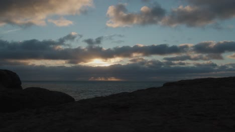 Timelapse-of-North-Beach-or-Praia-do-Norte-in-Portugal,-moving-clouds-and-sun-falling-down