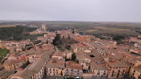 tilt-up-Aerial-view-of-Segovia-Alcazar-and-city-during-winter-cloudy-morning-with-snow-flakes-falling