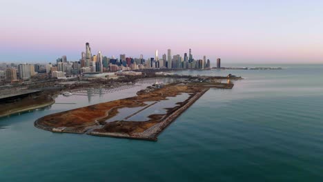 Aerial-view-in-front-of-the-Northerly-Island-with-the-Chicago-cityscape-in-the-background,-spring-sunrise-in-USA---tracking,-drone-shot