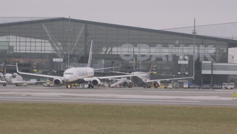 Wide-shot-of-rolling-airplane-at-Airport-Lecha-Wałęsy-in-Gdańsk-during-Cloudy-day