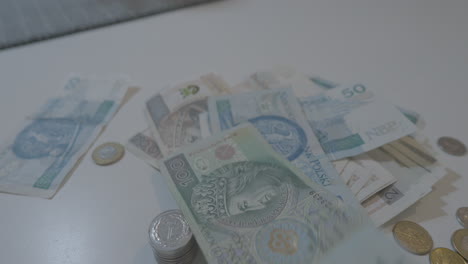 Polnische-Zloty-Papierbanknote-Fällt-Mit-Münzen-Auf-Den-Tisch