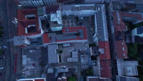 Top-down-aerial-of-Bratislava-streets-rooftops,-tilt-up-reveals-striking-townscape-at-blue-hour