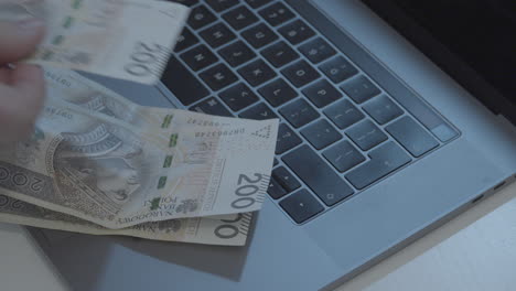 Counting-banknotes-by-putting-them-down-on-the-laptop-keyboard---Polish-money