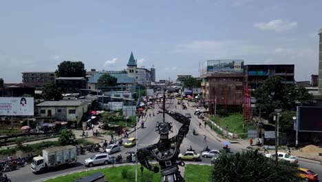 Aerial-view-over-the-Rond-Point-Deido-statue-in-Douala-city,-Cameroon,-Africa